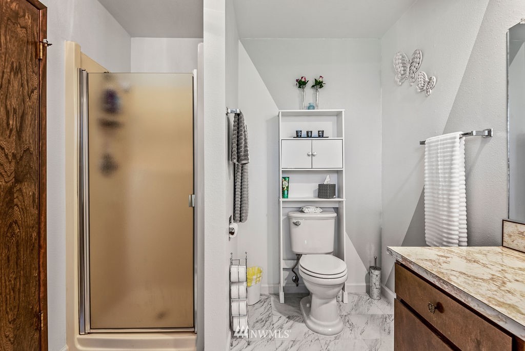 2363 40th Avenue, Unit 7 Longview, WA 98632 - Photo 15 of 25 a bathroom with a granite countertop toilet a sink and a shower