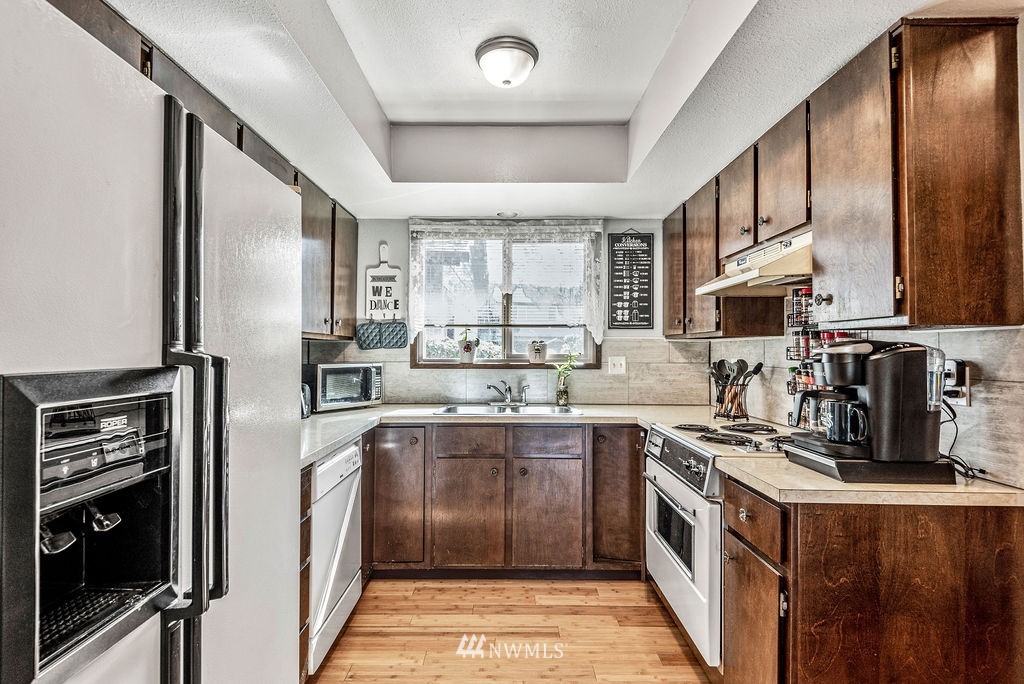 2363 40th Avenue, Unit 7 Longview, WA 98632 - Photo 6 of 25 a kitchen with stainless steel appliances granite countertop a stove a sink dishwasher a refrigerator and a microwave