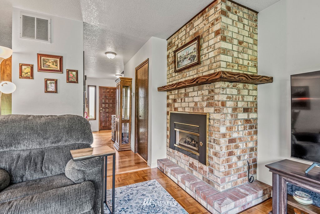 2363 40th Avenue, Unit 7 Longview, WA 98632 - Photo 8 of 25 a living room with furniture a fireplace and a flat screen tv