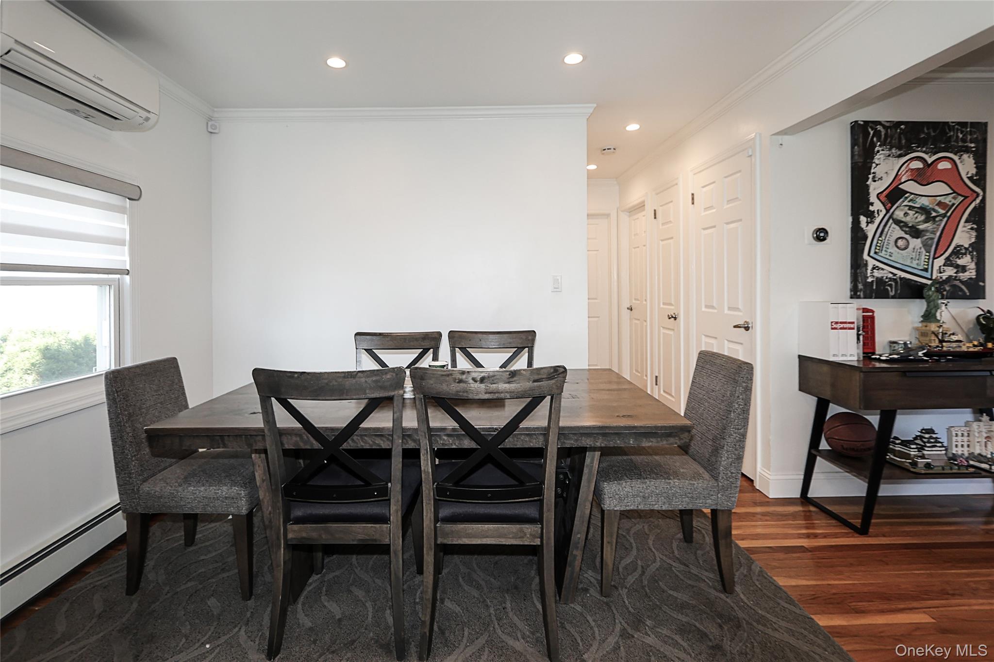 132 Bethel Road Albertson, NY 11507 - Photo 11 of 28 Dining area with crown molding, a wall mounted air conditioner, recessed lighting, dark wood-style floors, and a baseboard radiator
