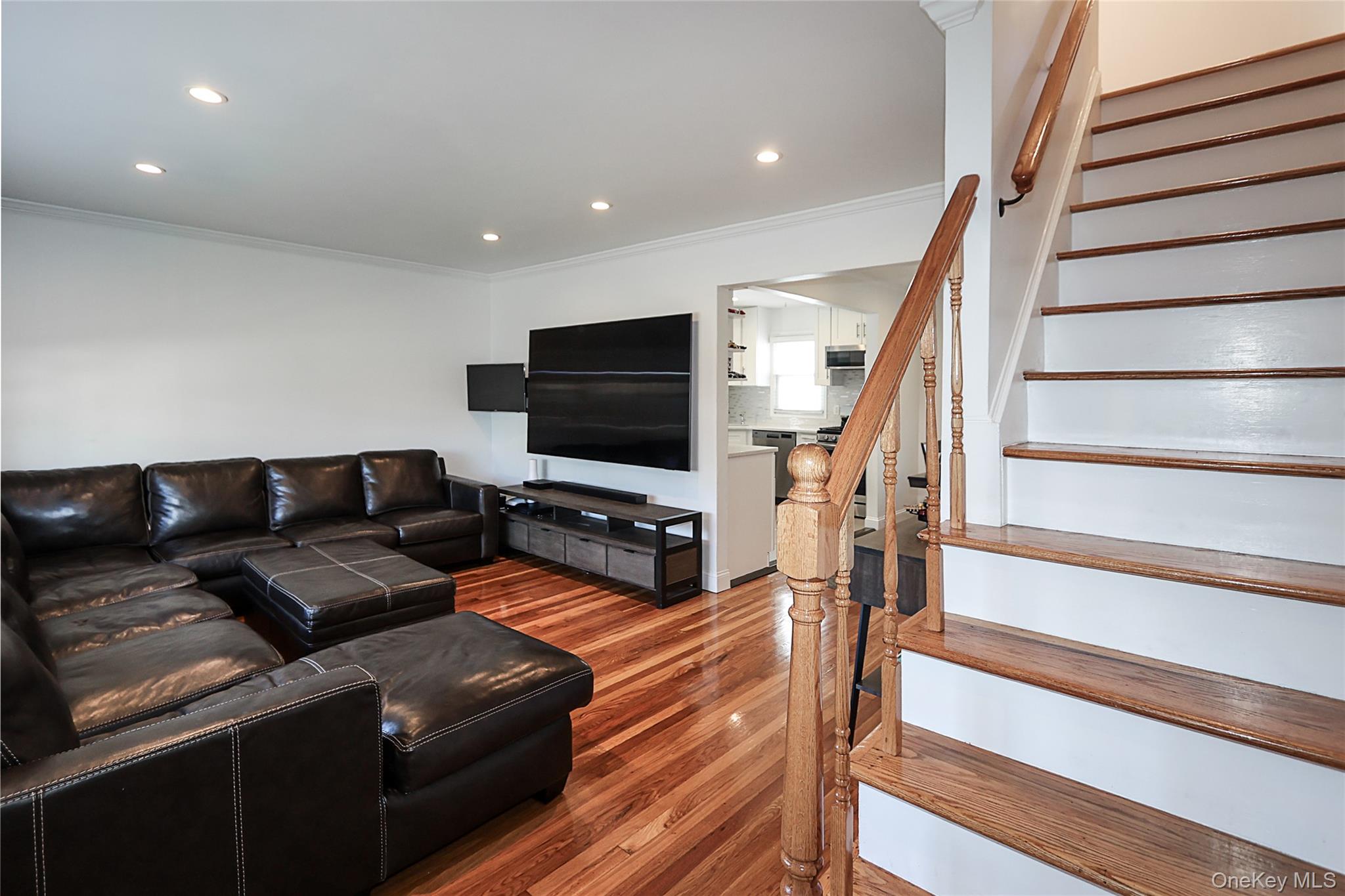 132 Bethel Road Albertson, NY 11507 - Photo 13 of 28 Living room with stairs, wood finished floors, ornamental molding, and recessed lighting