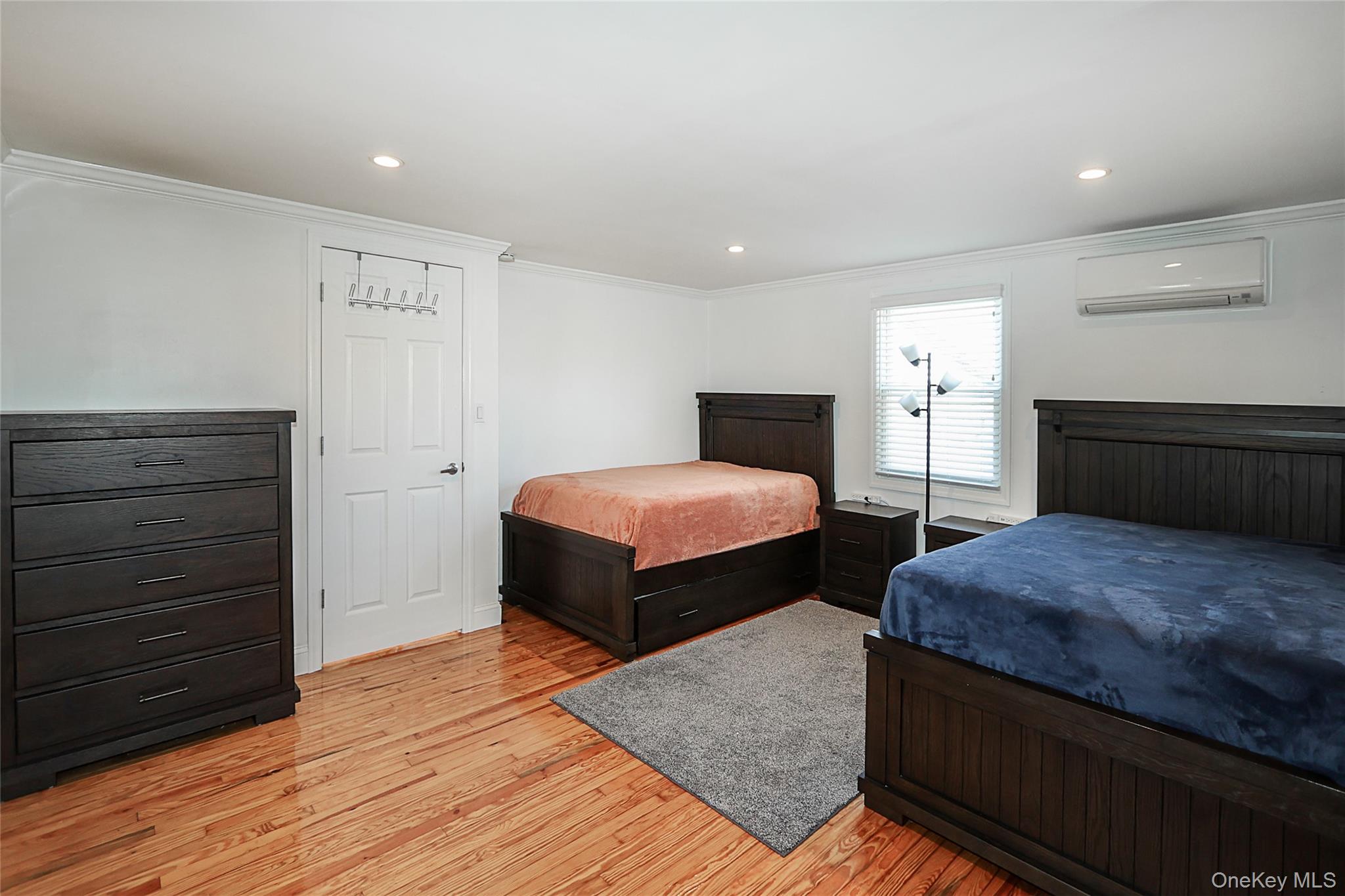 132 Bethel Road Albertson, NY 11507 - Photo 18 of 28 Bedroom with light wood finished floors, recessed lighting, ornamental molding, and a wall mounted air conditioner