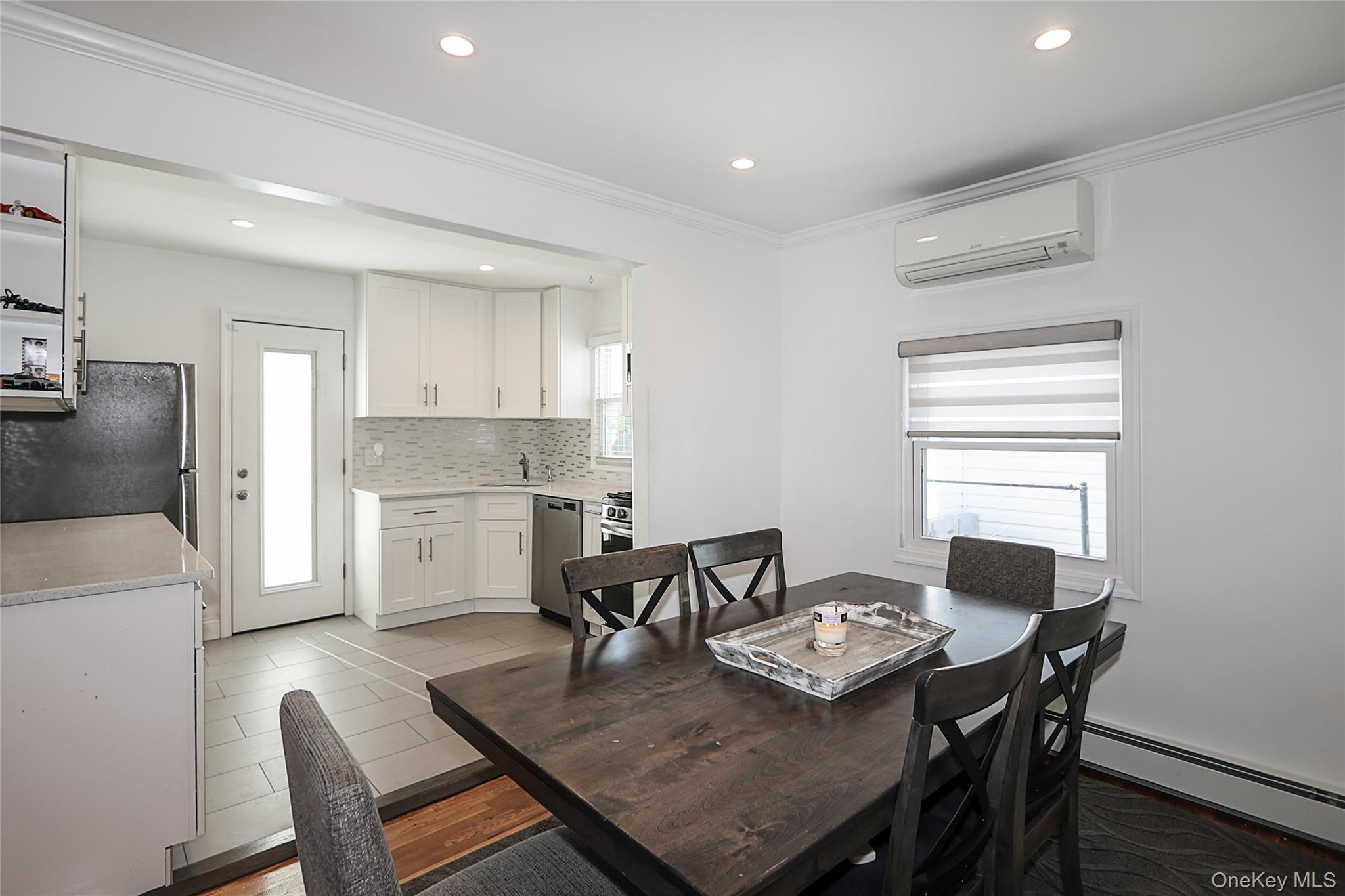 132 Bethel Road Albertson, NY 11507 - Photo 9 of 28 Dining area with a baseboard heating unit, ornamental molding, an AC wall unit, recessed lighting, and light tile patterned floors