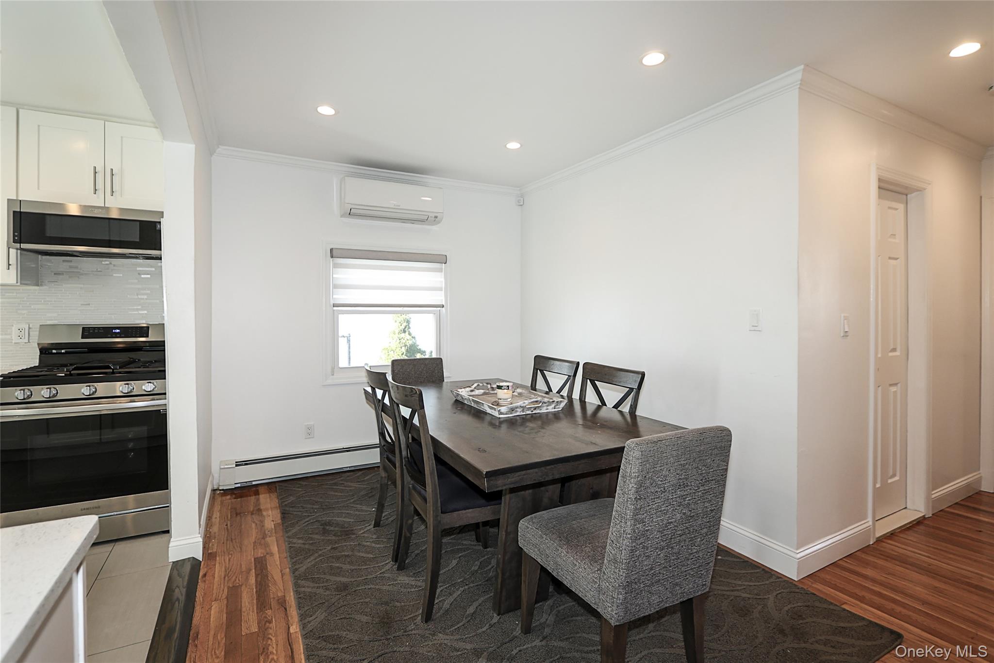 132 Bethel Road Albertson, NY 11507 - Photo 10 of 28 Dining room featuring dark wood-type flooring, recessed lighting, crown molding, a baseboard radiator, and a wall mounted air conditioner