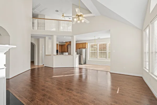 an empty space with wooden floor and large windows