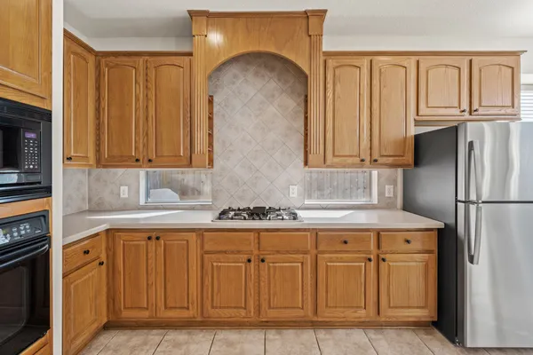 a kitchen with white cabinets and refrigerator