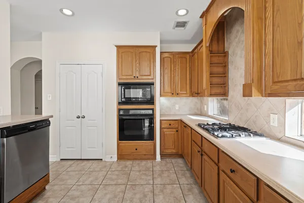 a kitchen with stainless steel appliances granite countertop a stove a sink and a refrigerator