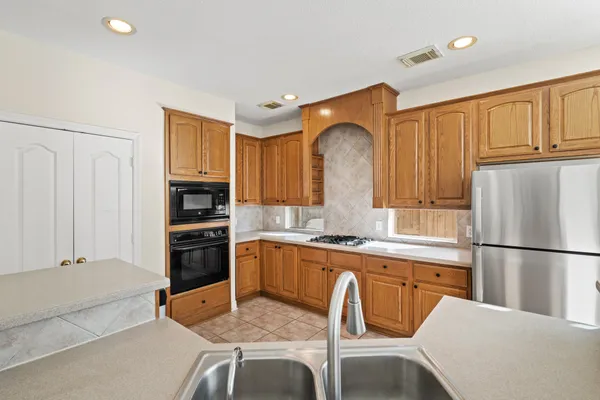 a kitchen with stainless steel appliances granite countertop a refrigerator sink and cabinets