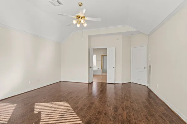 a view of an empty room with wooden floor