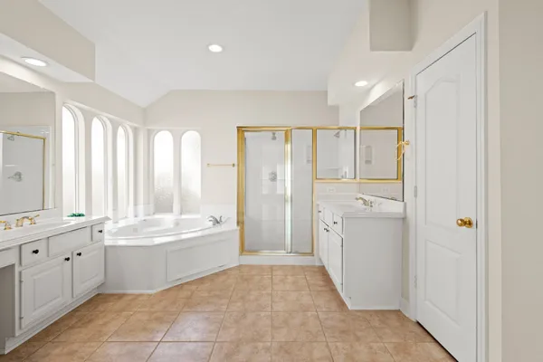 a bathroom with a tub sink shower and mirror