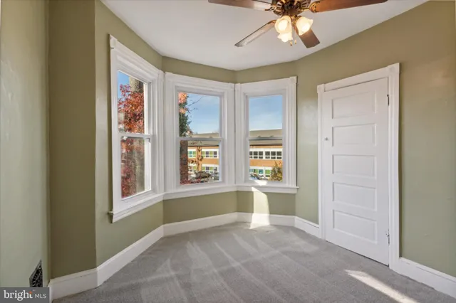 a view of an empty room with a window and bathroom