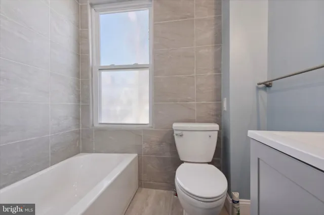 a white toilet sitting next to a bath tub