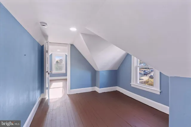 a view of an empty room and window with wooden floor