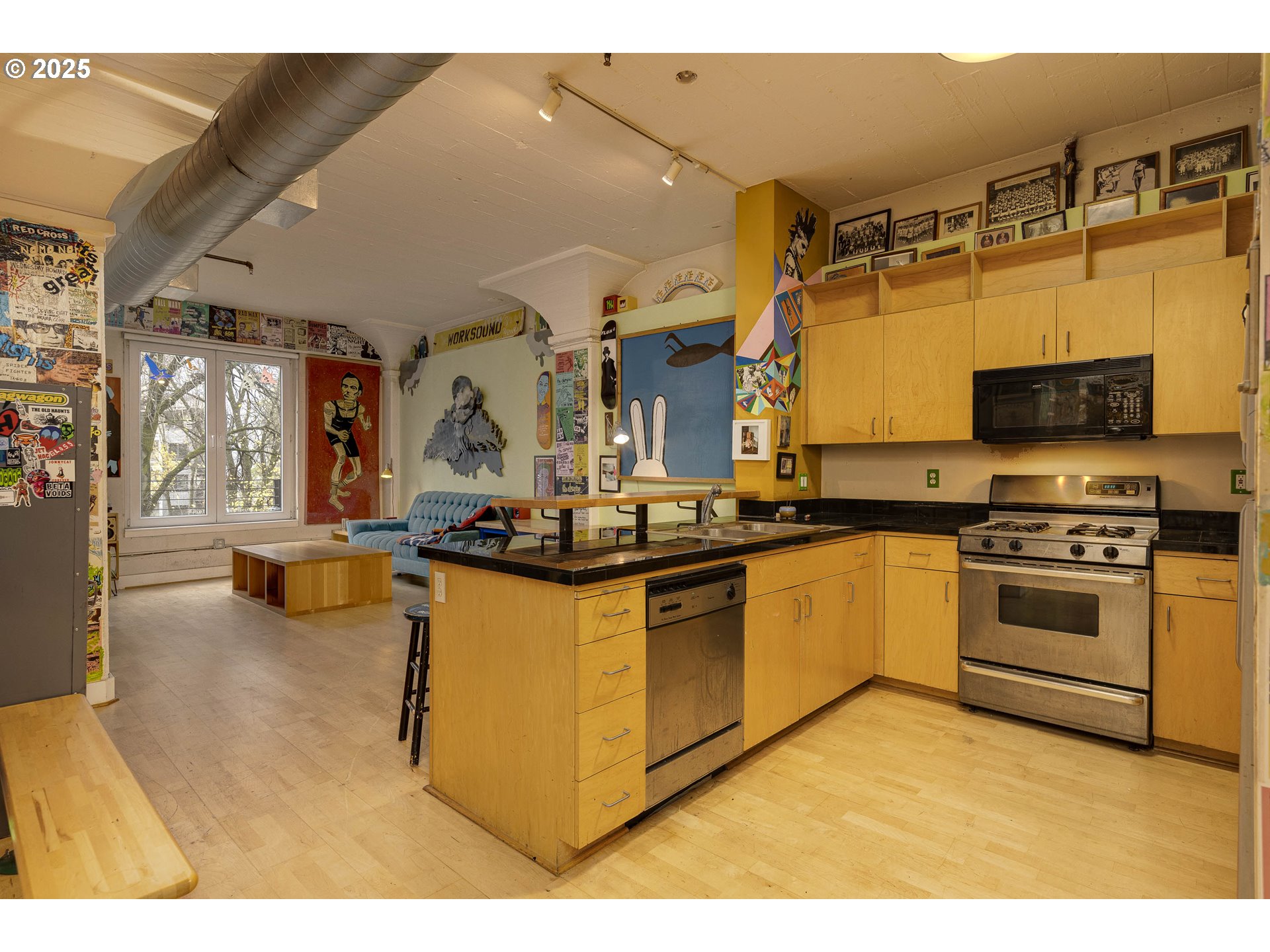 300 Northwest 8th Avenue, Unit 401 Portland, OR 97209 - Photo 16 of 37 a kitchen with stainless steel appliances kitchen island granite countertop a sink and cabinets