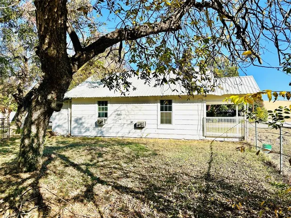front view of a house with a large tree
