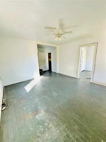 an empty room with windows and fireplace