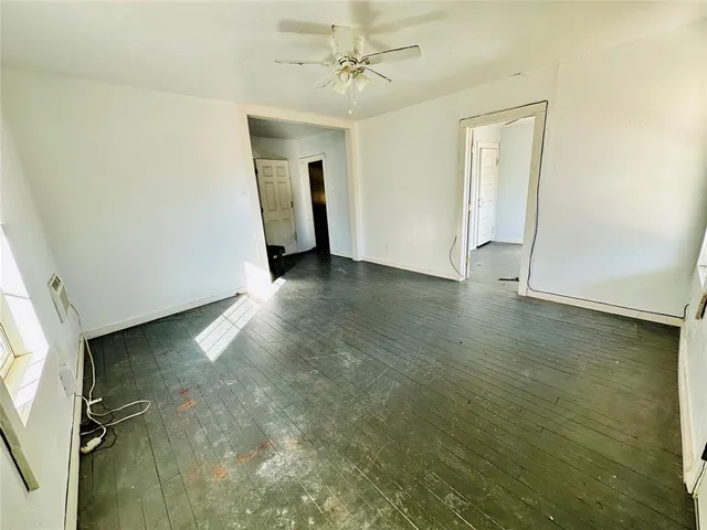 wooden floor in an empty room with a window