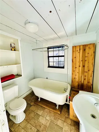 a bathroom with a sink and bathtub with toilet