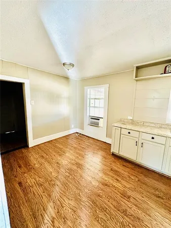 a view of a bedroom with wooden floor and cabinet