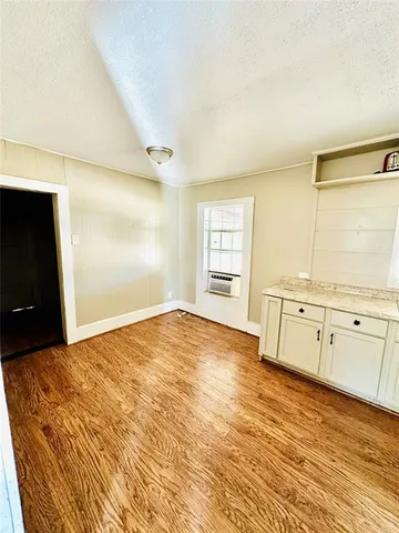 a view of a bedroom with wooden floor and cabinet