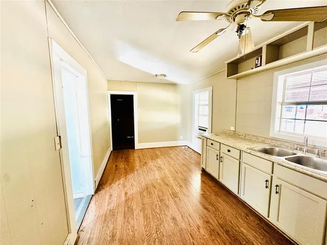 a view of a kitchen with a sink and wooden floor