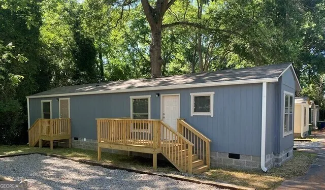 a view of a house with a yard and wooden fence