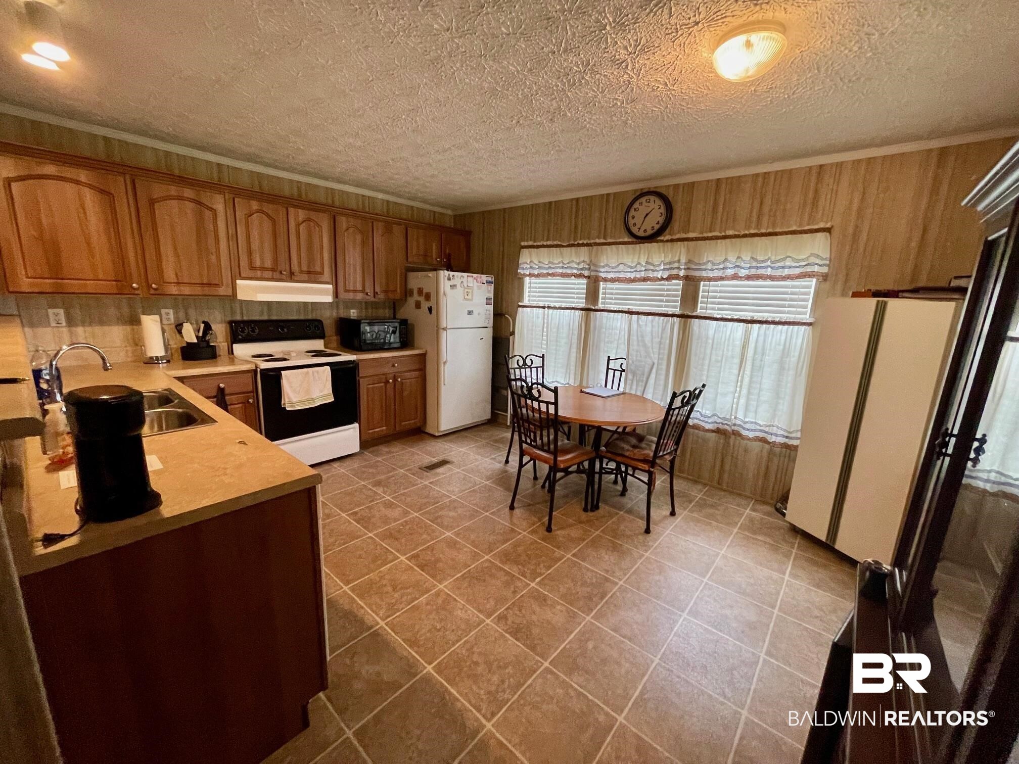 15338 Windbigler Drive Foley, AL 36535 - Photo 11 of 28 Kitchen with ornamental molding, white appliances, a textured ceiling, sink, and light tile patterned flooring