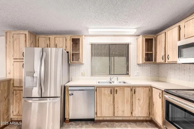 a kitchen with stainless steel appliances granite countertop a refrigerator a stove top oven a sink and dishwasher