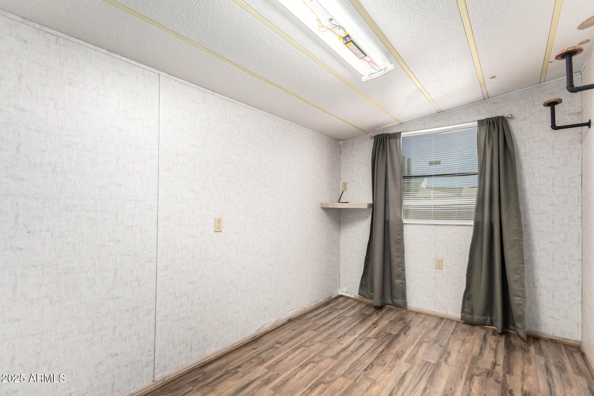 834 South Meridian Road, Unit 116 Apache Junction, AZ 85120 - Photo 25 of 42 a view of an empty room with wooden floor