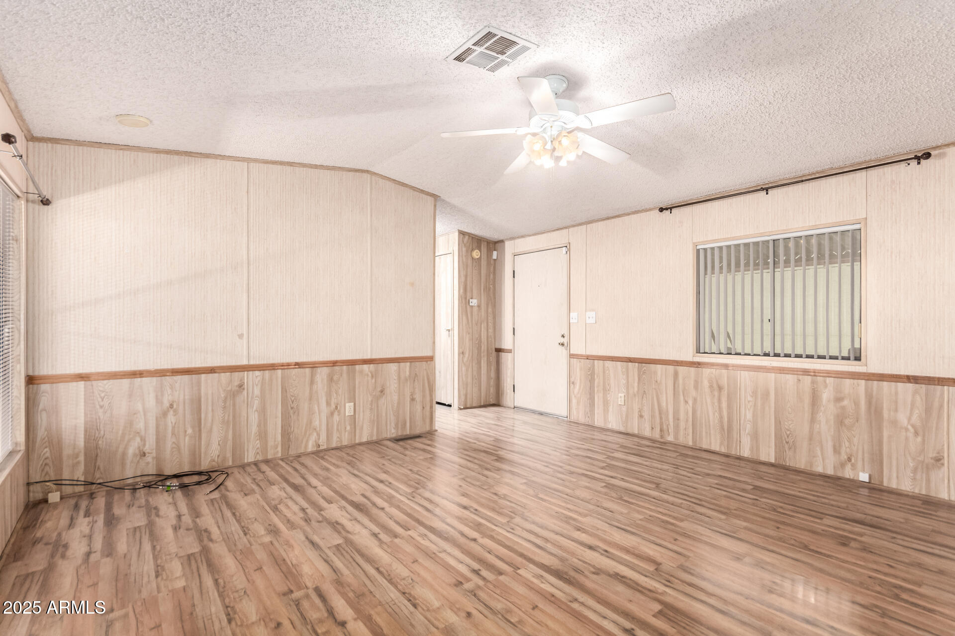 834 South Meridian Road, Unit 116 Apache Junction, AZ 85120 - Photo 9 of 42 a view of an empty room with wooden floor and a window