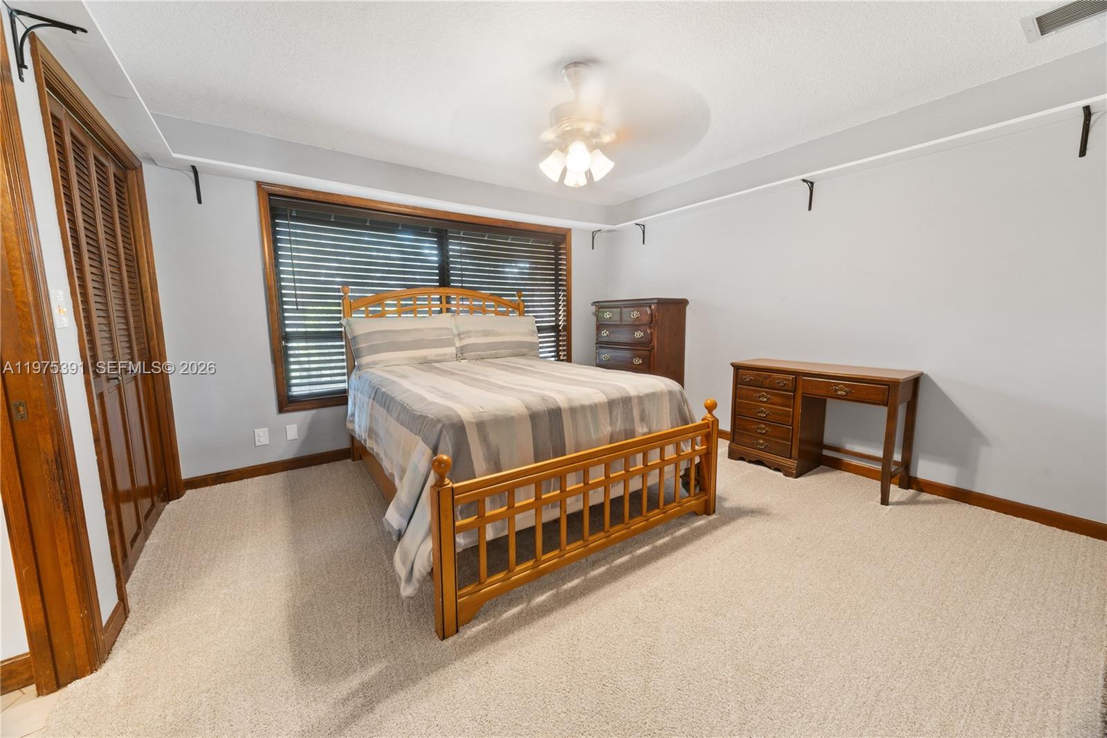 1872 Southeast Colony Way Jupiter, FL 33478 - Photo 19 of 26 a room with a bed and a ceiling fan