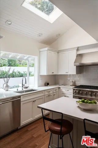 a kitchen with a stove sink and cabinets