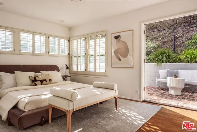 a large bed sitting in a bedroom next to a window