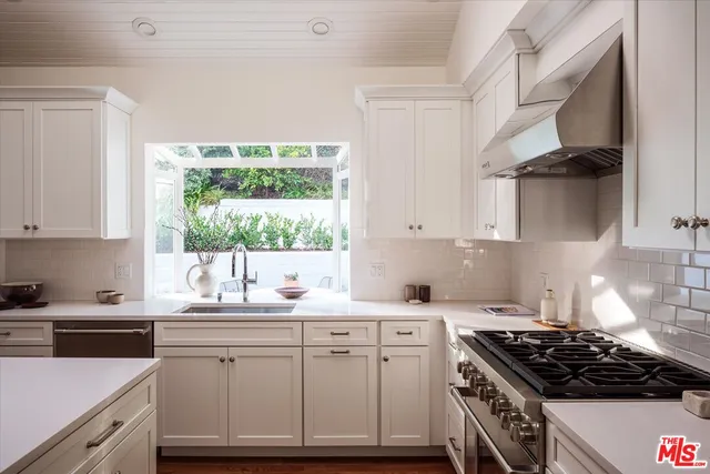 a kitchen with a sink a window and cabinets