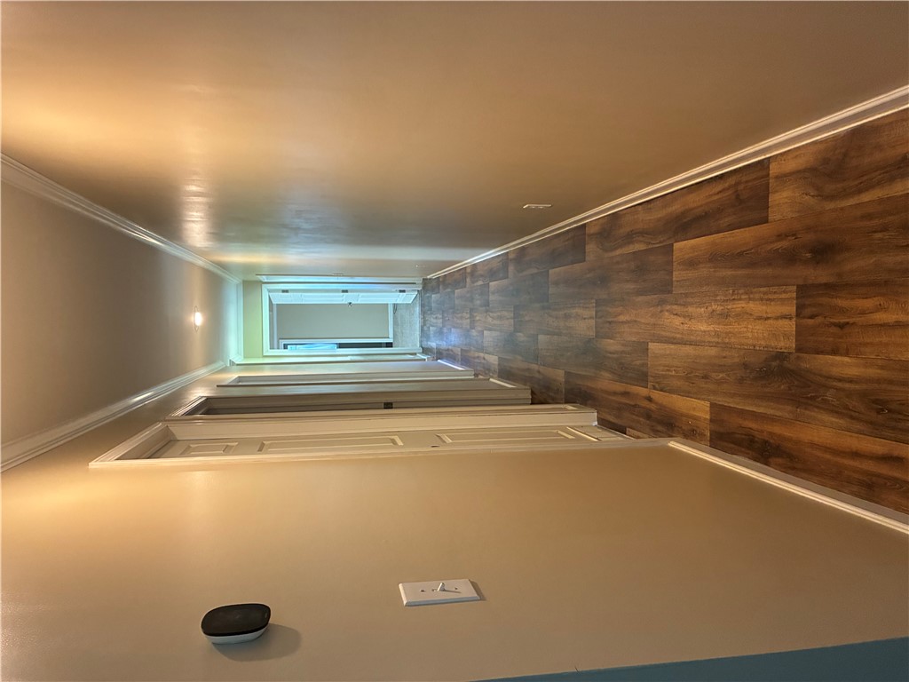 Gleaming wood-look floors and clean crown molding line this long central hallway.