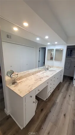 a bathroom with a granite countertop sink and a large mirror