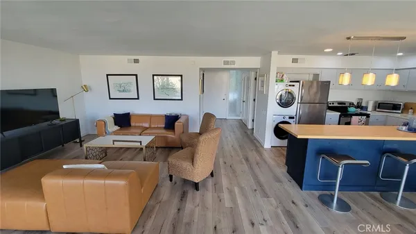 a living room with furniture a wooden floor and a flat screen tv