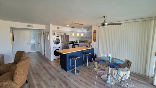 a living room with furniture a dining table and wooden floor