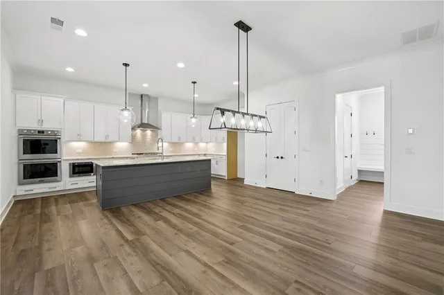 a kitchen with stainless steel appliances kitchen island granite countertop a stove and a refrigerator