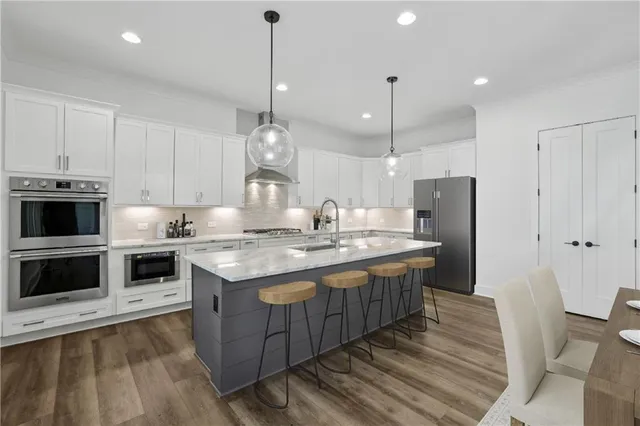 a kitchen with a sink chandelier and wooden floor