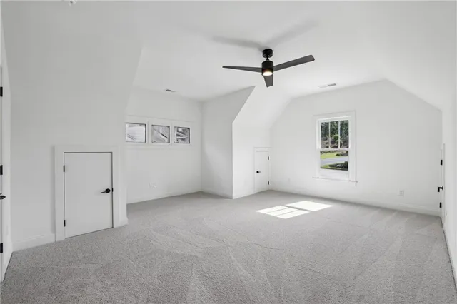 an empty room with a window and a ceiling fan