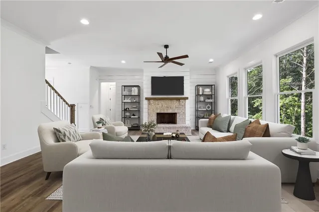 a living room with furniture a large window and a fireplace