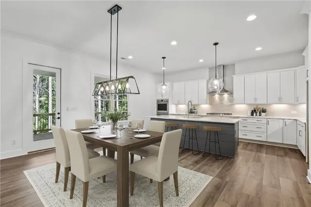 a large kitchen with stainless steel appliances kitchen island a large counter top a sink a stove and a wooden floors