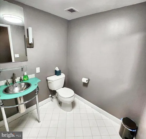 a bathroom with a toilet a sink and a mirror