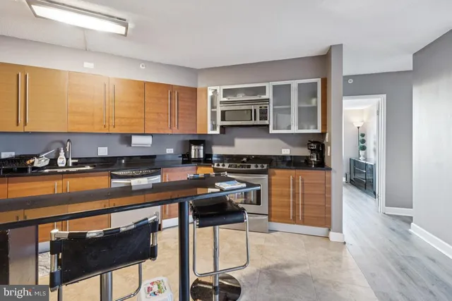 a kitchen with stainless steel appliances granite countertop a stove a sink and a refrigerator