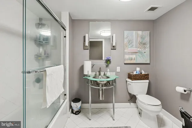 a white toilet sitting next to a bathroom sink