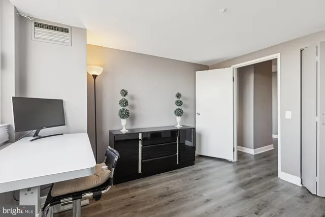 a view of a workspace with furniture and wooden floor