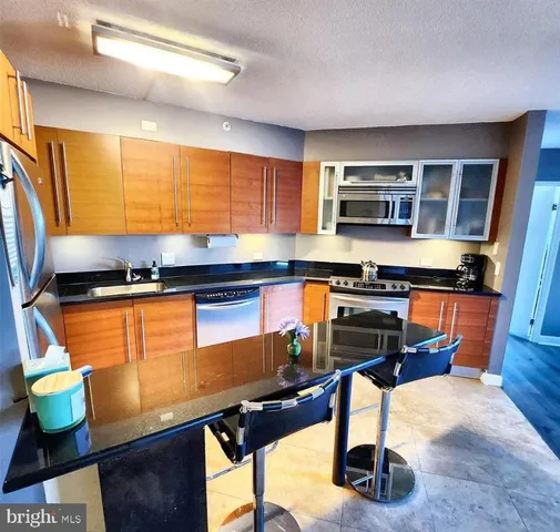a kitchen with stainless steel appliances kitchen island granite countertop a sink and cabinets