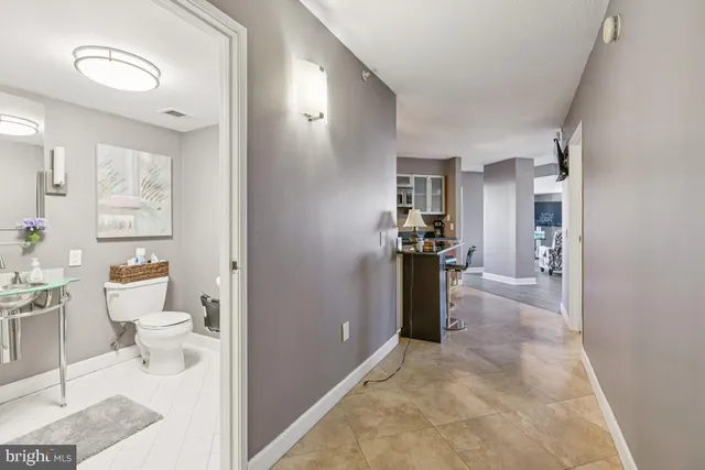 a view of a hallway with bathroom and a view of bathroom