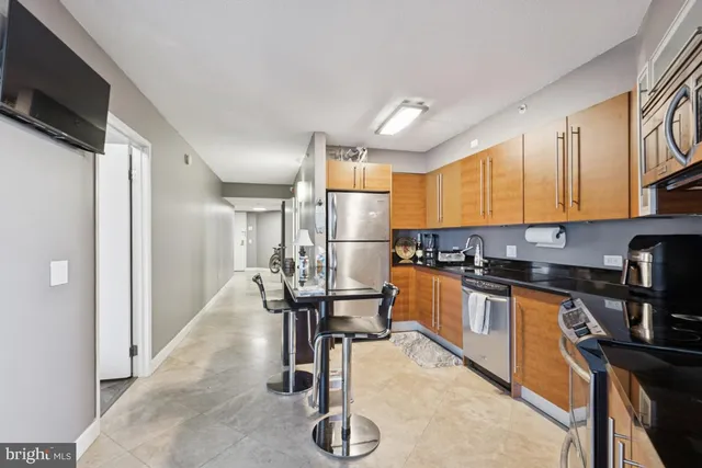 a kitchen with stainless steel appliances granite countertop a refrigerator and a stove top oven
